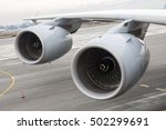 Airbus A380 airplane's engines on a wing on a runway at an airport. 