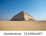 Small photo of The Pyramid of Bent (also known as the False, or Rhomboidal Pyramid because the angular slope changed) of Pharaoh Sneferu with a well-preserved original limestone casing. Egypt. Dahshur (or Dashur).