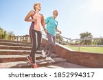 Small photo of Energize your morning. Full length shot of active mature family couple in sportswear running together in the park on a sunny morning. Joyful senior couple working out outdoors