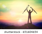 International Day of Persons with Disabilities (IDPD) concept: Silhouette a disabled man standing up and raising his crutches over mountain autumn sunset background