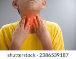 Small photo of Asian boy touching the neck due to a sore throat or Itching in the throat causes of Irritation and infection in the respiratory tract and bacterial infection concept of medical and health care.