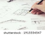An architect engineer creates a working drawing sketch for building a house building. Architectural design projects concept. Engineering and architecture drawings