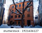 Small photo of Stockholm, Sweden - Feb 2021: Empty outdoor sitting of a restaurant in antique house at the Old Town at the square Branda Tomten during pandemic of coronavirus on a winter day. Selected focus.