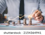 Small photo of Business man putting coins Business growth and investment chart, strategic planning to increase profits from doing business, long-term investment planning.