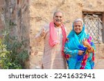 Old indian farmer couple showing thumps up at home