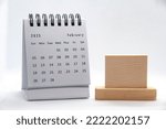 February 2023 white desk calendar on white background with customizable wooden space for text. Calendar concept.