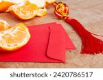 Small photo of Peal Mandarin oranges and Chinese New Year red envelope. Chinese New Year celebration concept.