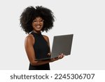 woman holding laptop computer typing on keyboard looking at camera, black woman
