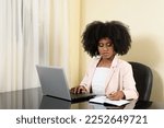 Small photo of woman makes annotation on her notebook at her workplace, young black woman