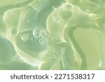 Small photo of The texture of a green gel or serum with hyaluronic acid for the face. Cosmetic transparent liquid cream with oxygen bubbles. Wellness and beauty concept. Sanitizer, virus protection. Soft focus.