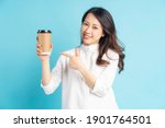 Beautiful Asian businesswoman holding paper coffee cup in her hand
