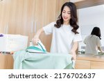 Young Asian woman ironing clothes
