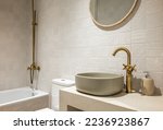 Small photo of Bright bathroom in soothing pastel colors with textured ceramic tiles. Attractive oval sink. Faucets made of copper in beautiful expensive color. Interior details harmoniously complement each other.
