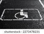 Handicap symbol on road. Road marking on the asphalt with parking spaces for the disabled. wheelchair symbol of disabled parking lot for handicapped person on concrete road