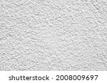 Rough surface of a concrete wall painted in greyish white, concrete wall background, blurred white background.