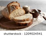 Artisan sliced toast bread with butter and sugar on wooden cutting board. Simple breakfast on grey concrete background. Closeup view