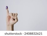 Small photo of Purple ink applied on little finger after pemilu or Indonesian presidential election