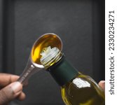 Small photo of Pouring olive oil into a measuring spoon, measuring a tablespoon of oil