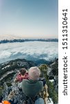 Small photo of Man and boy sitted on the peak of the mountain