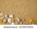 Composition with text HELLO SUMMER seashells, pebbles, mockup on sand background. Blank, top view, still life, flat lay. Sea vacation travel concept tourism and resorts. Summer holidays