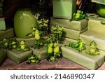 Small photo of Proserpine, Queensland, Australia - April 2022; A collection of cute green frogs in various human poses in a store display designed to make you smile.