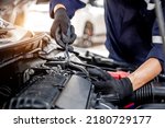 Small photo of Car care maintenance and servicing, Close-up hand technician auto mechanic using the wrench to repairing change spare part car engine problem and insurance service support.