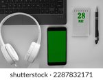 Small photo of calendar date on a light background of a desktop and a phone with a green screen. May 28 is the twenty-eighth day of the month.