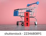Small photo of Shopping trolley with red upward arrow. Inflation, rising cost of living, overprice and expensive concept