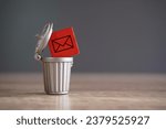 Small photo of Closeup image of wooden cube with mail icon inside trash can. Junk mail and spam mail concept.
