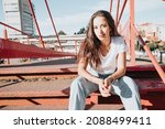 Small photo of Cool hipster african young girl with curly hair, street hip hop style, looking serious defiant to camera, dynamics and expression. Copy space, social network concept. White tshirt denim jeans
