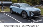 Small photo of Monroeville, Pennsylvania, USA October 15, 2023 A new, blue Cadillac Lyric electric vehicle for sale at a dealership on a fall day