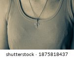 Golden cross on a chain on a woman's chest, monochrome filtering