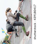 Small photo of STOCKHOLM, SWEDEN - MAY 14, 2016: Two woman climbing the rampage obstacle, hanging in rope in the obstacle race Tough Viking Event in Sweden, May 14, 2016