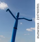 Small photo of Blue inflatable man, also called sky dancer, fly guy, tall boy, tube man, or wacky waving inflatable arm flailing tube man at market in Mortsel