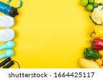 Healthy lifestyle, food and sport concept. athlete's equipment and fresh fruit and vegetable on yellow background.