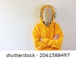 an unknown person with a hidden face behind a paper mask in a hood and with headphones on his head. concept without a face, a person of invisibility, faceless.