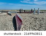 Small photo of Al Chibayish, Iraq. November 1st, 2018 Boats on dried cracked earth during a drought in the Southern Marshes of Iraq. Climate change and political instability causing a crisis for local fishermen and