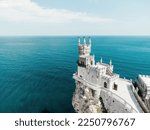 Small photo of Crimea Swallow's Nest Castle on the rock over the Black Sea. It is a tourist attraction of Crimea. Amazing aerial view of the Crimea coast with the castle above abyss on sunny day.