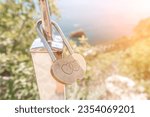 Small photo of Wedding Heart Golden Lock on stainless iron fence. Valentine's day. Symbol of eternal love. A wedding tradition all over the world to hinder the lock. Monument on the wedding day.