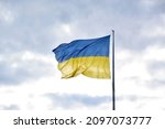 Small photo of Large national flag of Ukraine flies in the blue sky. Big yellow blue Ukrainian state banner in the Kharkiv city. Independence, flag, Constitution Day, National Holiday, text space.