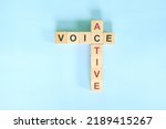 Small photo of Active voice topic in English grammar teaching. Wooden block crossword puzzle flat lay in blue background.