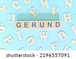 Small photo of Gerund concept in English grammar and learning class lesson. Wooden blocks typography word flat lay in blue background.