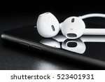 Close-up headphone stack on phone, modern smartphone's earbuds device accessories