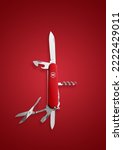 Small photo of Dusseldorf, NRW, Germany, Victorinox red classic swiss pocket foldable knife isolated on red background