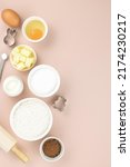 Small photo of Baking ingredients and tools - flour, sugar, butter, eggs, cocoa, milk, baking powder, rolling pin, whisk, cookie cutters. Top view, copy space. Ingredients for cake, cookies, muffins.