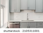 Small photo of Modern Condo Kitchen with Gray Cabinets and White Tile Backsplash and Empty Countertops