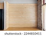 Small photo of Empty Oak Slat Accent Wall. Vacant living room for virtual staging. Wood and brick accents in industrial style loft.