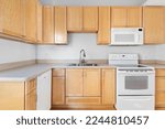 Builder Grade Kitchen with Oak Shaker Cabinets and White Appliances. Basic Kitchen in rental apartment.