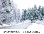 Road trip concept. Empty country road in winter. Trees and roadside in the snow. Winter trip.