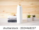 Towel, hair brush, shampoo and succulents on a wooden background